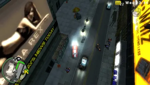 Liberty City street at night seen from above in GTA Chinatown Wars: cars on the road, a newspaper-style poster on a facade to the left and a large parody discount-store sign with the tagline 'buy more, spend less' lit up on the right