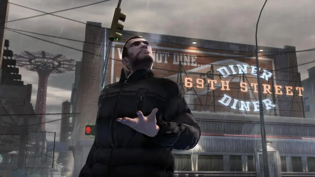 Niko Bellic in a black jacket looks up in the rain on a Liberty City street, the glowing 69th Street Diner sign and a Ferris wheel in the distance