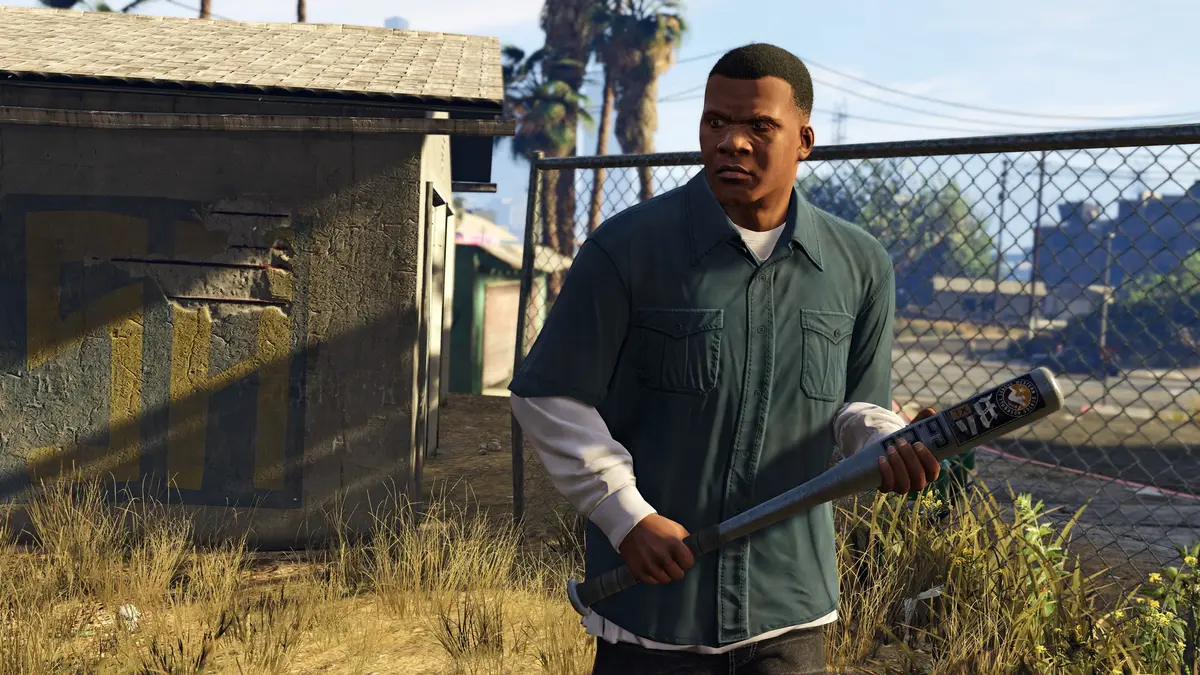 Franklin Clinton, a young man in a green shirt holding a baseball bat, in a fenced-in alley in a South Los Santos neighborhood, palm trees and a run-down house in the background