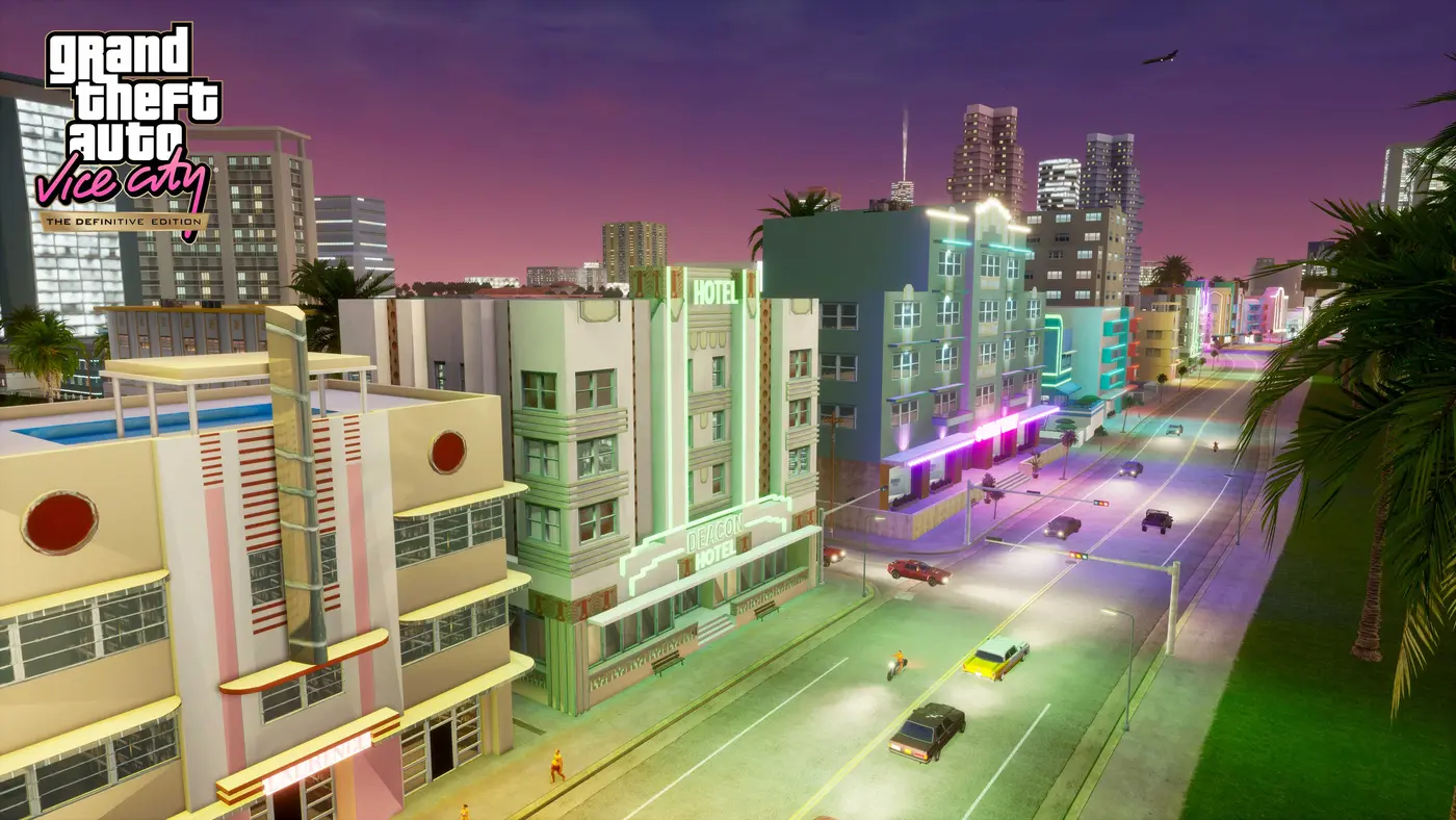 Official screenshot from GTA Vice City The Definitive Edition: an Ocean Beach avenue at dusk, pastel Art Deco hotels with green and pink neon, palm trees, 80s cars and a purple sky