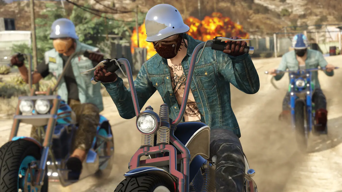 Three bikers in half helmets, vests and denim jackets ride ape-hanger choppers along a dusty trail, an explosion in the background