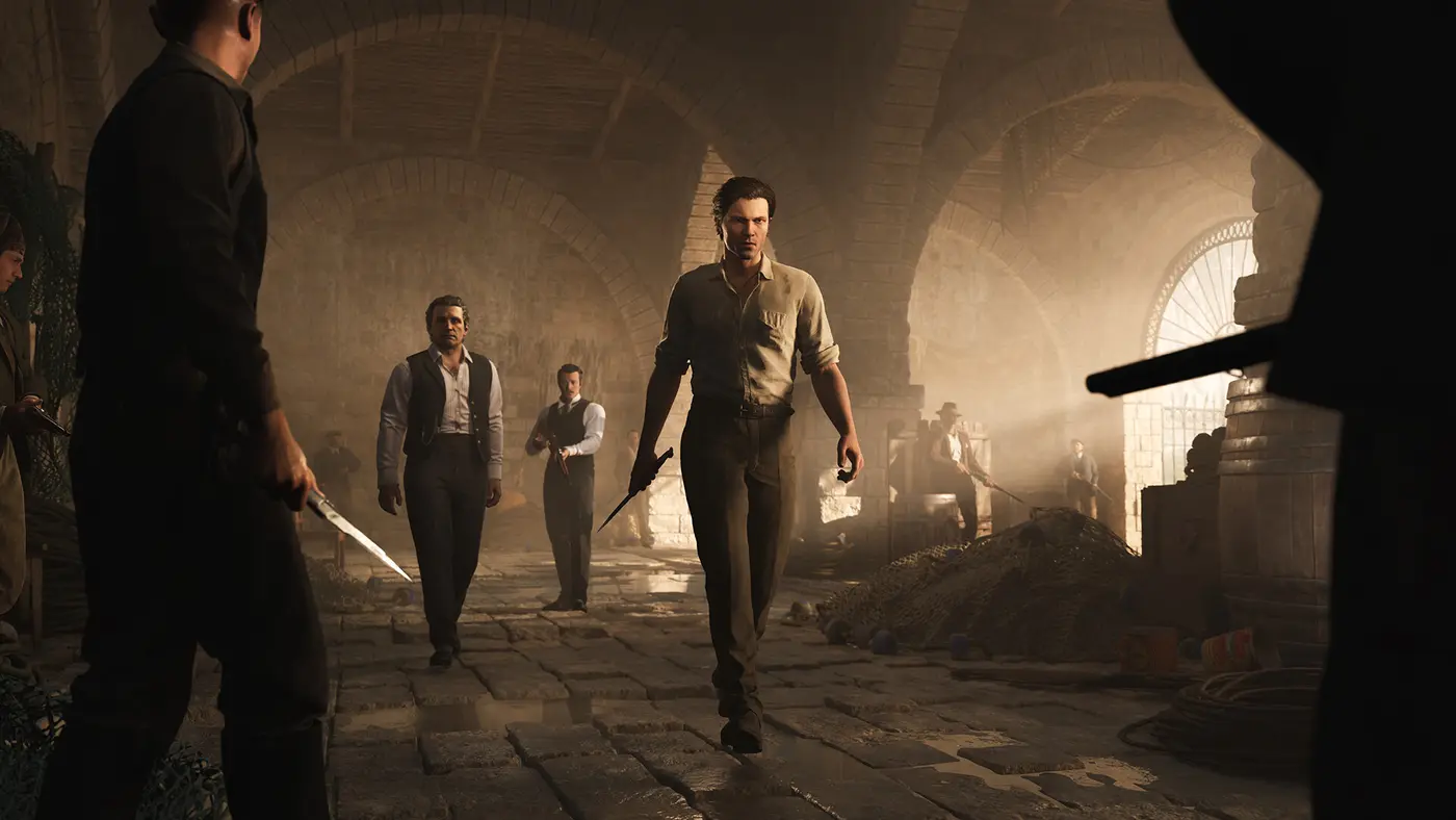 Enzo Favara, the hero of Mafia: The Old Country, moves forward knife in hand through a vaulted stone cellar, surrounded by men in period dress armed with knives and rifles, golden light filtering through the arches