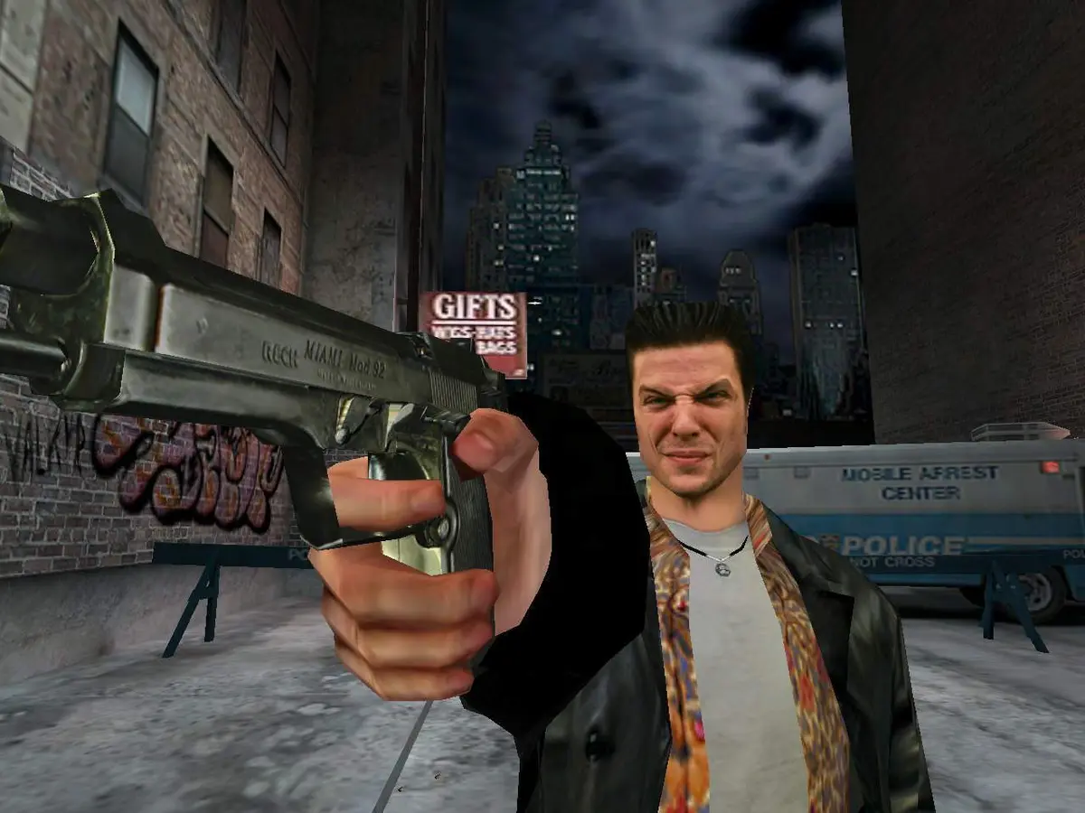 Max Payne (2001) screenshot: Max points a pistol toward the camera on a nighttime New York street, graffiti-covered brick facades, a stormy sky and a police van in the background