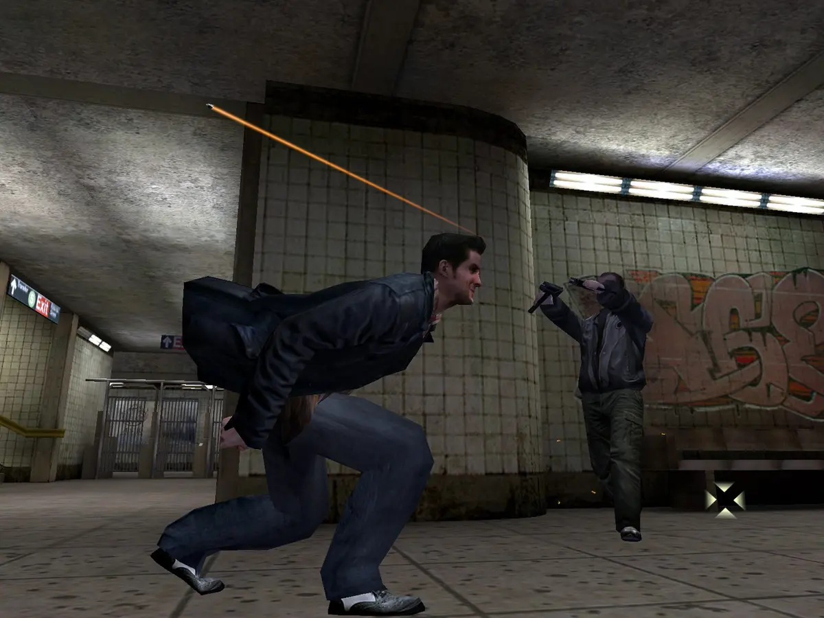 Max Payne (2001) screenshot: Max, in a leather jacket, dives sideways through a tiled subway station while a gunman in a gray jacket fires at him, an orange bullet trail streaking across the frame