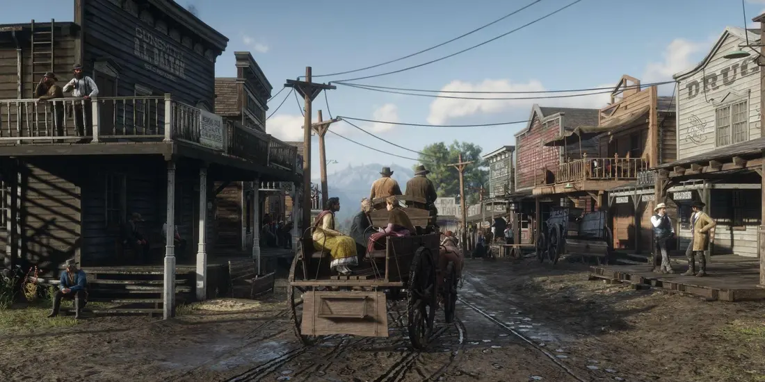 Muddy main street of a Western town in Red Dead Redemption 2: wooden storefronts of a gunsmith and a drugstore, passersby, a horse-drawn carriage, and mountains in the distance