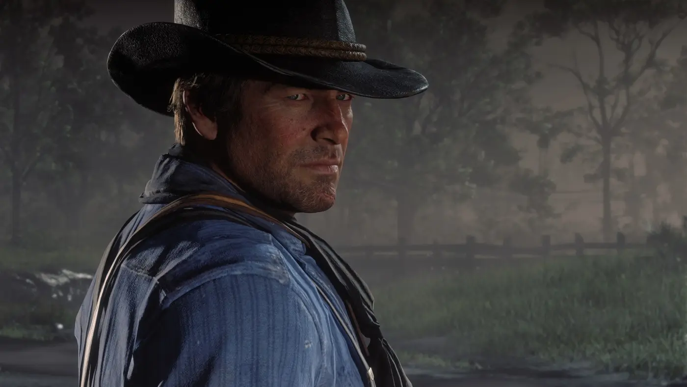 Close-up of Arthur Morgan in Red Dead Redemption 2, detailed face, stubble and a worn cowboy hat in soft forest light