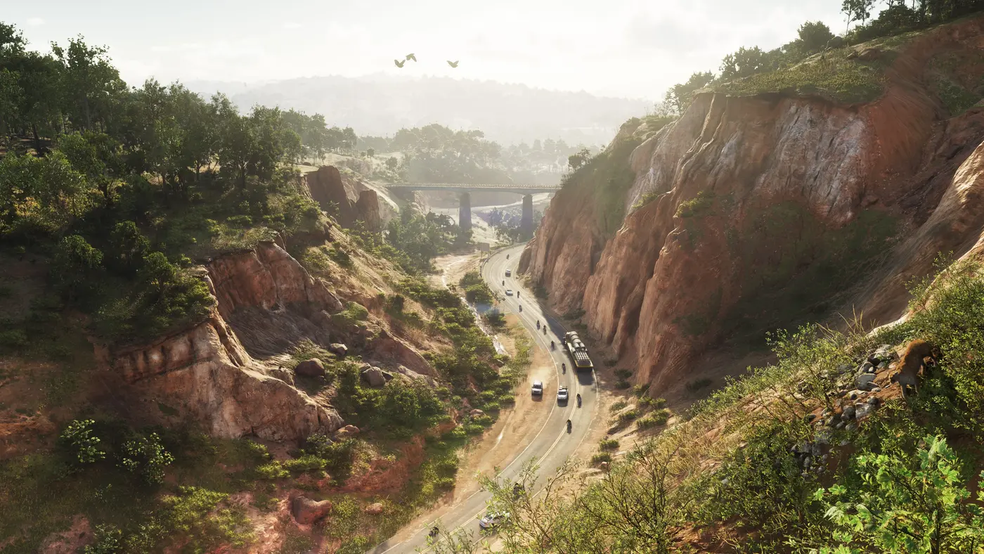 A red-cliff canyon crossed by a winding road and a bridge in the distance in GTA VI, wooded hills of the state of Leonida