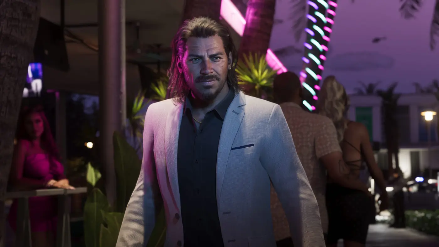 A Vice City street at night in GTA 6: a man in a light jacket walks down a sidewalk bathed in pink and turquoise neon, palm trees and passersby lit up by the glowing signs