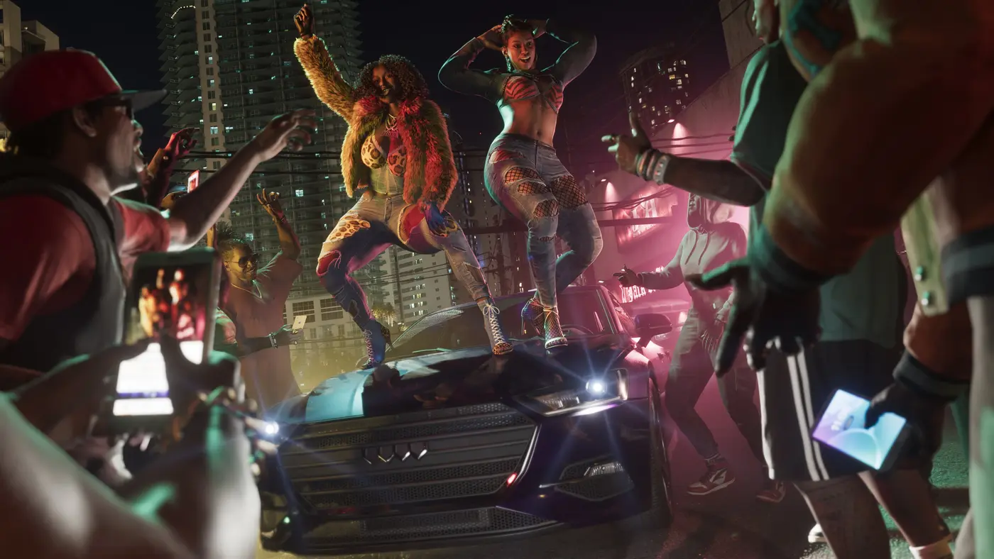 The Real Dimez duo in GTA 6, two women dancing on the hood of a car at a nighttime gathering in the city, a crowd around them with phones in hand, lit skyscrapers in the background